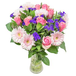 As a local florist near Rose Lane, arranging this bouquet is a meditative delight. The interplay between the blush-pink gerberas and classic roses feels luminous, like pink clouds drifting over the greens of Marks Gate fields. The petals softly merge, delicate hues swirling together - a gentle watercolor effect - while clusters of vivid purple statice pop with cheerful exuberance. The foliage, cool and fresh, brings a damp woodland scent, grounding the ethereal blooms and conjuring the freshness of nearby Eastbrookend Country Park after morning rain. The composition is balanced and light, reminiscent of an optimistic spring day in Barking and Dagenham. Framed in a slender, transparent vase, these colours seem to gather and glow, inviting a closer look and a moment of quiet reflection. Suitable for celebrating a special recovery, brightening a new home, or adorning a bright kitchen in Marks Gate, this arrangement is a testament to thoughtful artistry and local pride. Each stem and leaf is chosen for its subtle beauty, creating a bouquet that feels handcrafted and heartfelt, bringing a breath of joy and serenity into homes across the area.